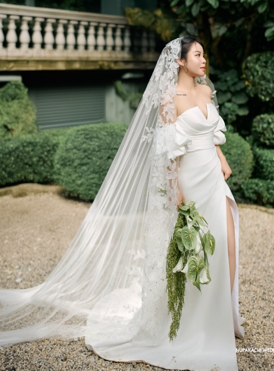 Cô dâu thật Dolinhanh Bridal với voan ren dài trong sân vườn